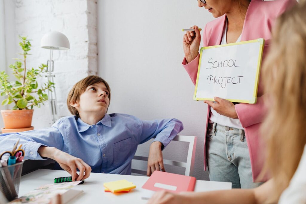 A teacher guiding teenagers through a school project in a modern classroom setting.